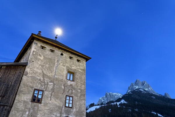 Full moon over the Pozza tower in the village of Pozza di Fassa. San Giovanni di Fassa, Fassa Valley, Trento province, Trentino Alto-Adige, Italy, Europe. 