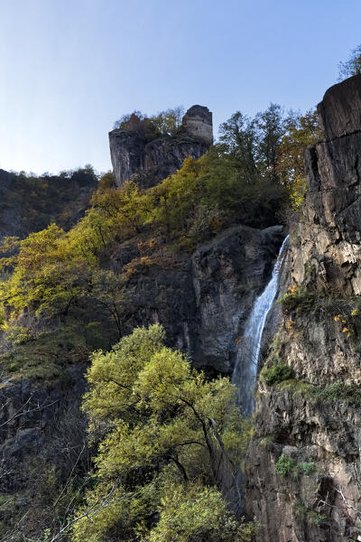 The ruins of the medieval Fingeller Castle (or Walbenstein) are on top of the cliff from which a waterfall flows. Bolzano, Trentino Alto-Adige, Italy, Europe. 