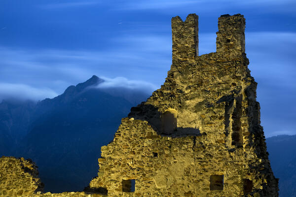 Moonlight over the ruins of Selva Castle. In the background Mount Cima Vezzena. Levico Terme, Trento province, Trentino Alto-Adige, Italy, Europe.