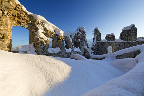 Ruins in the snow of the medieval Castellalto castle. Telve, Trento province, Trentino Alto-Adige, Italy, Europe.