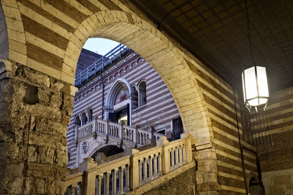 Verona: the Scala della Ragione framed by the arches of the porticoes of the Palazzo della Ragione. Veneto, Italy.