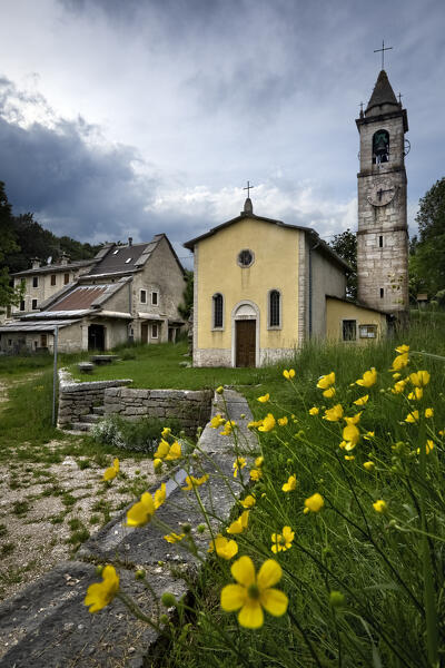 Hamlet of Camposilvano: the church of San Carlo Borromeo and ancient houses in Cimbrian architecture. Velo Veronese, Lessinia, Veneto, Italy.