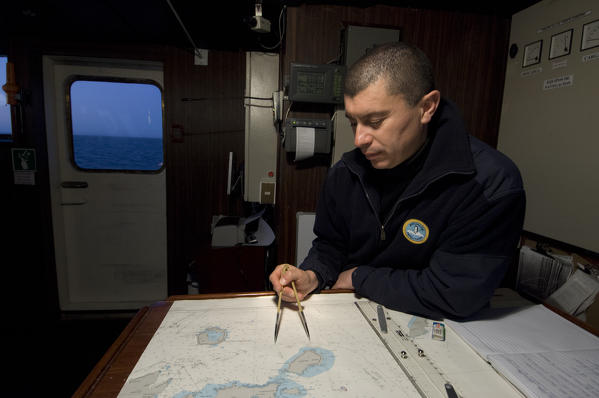 Antarctica, Antactic Dream ship, 3rd Officer Daniel Mena checking navigation charts, MR.