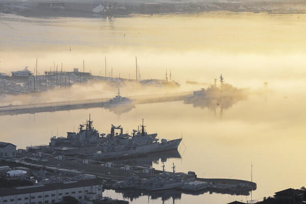 Maritime fog at dawn over Porto Mirabello and a part of the military arsenal of La Spezia, La Spezia province, Liguria district, Italy, Europe.
