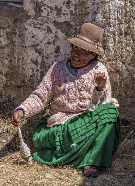 Ayamara woman in the typical costume working with a spindle. Aymaras are the native population of the Titicaca Lake area, in Bolivia, South America.