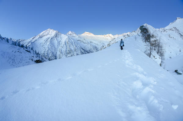 A hiker wait the dawn in Vallone di Campiglia, Gran Paradiso National Park, Valle Soana, Province of Turin, Canavese, Piedmont, italian alps, Italy
