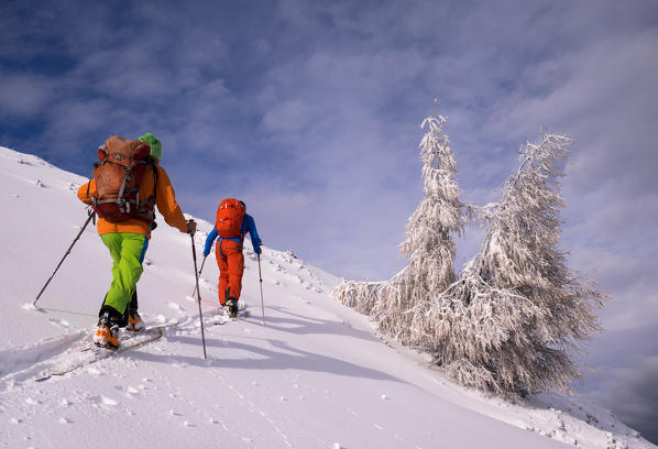 Two skiers touring in the sunlight after a snowfall, Cima della Rosetta, Valgerola, Italy, Alps