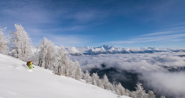 Skier over the clouds at Cima della Rosetta, Valgerola, Valtellina, Lombardy, Italy, Alps