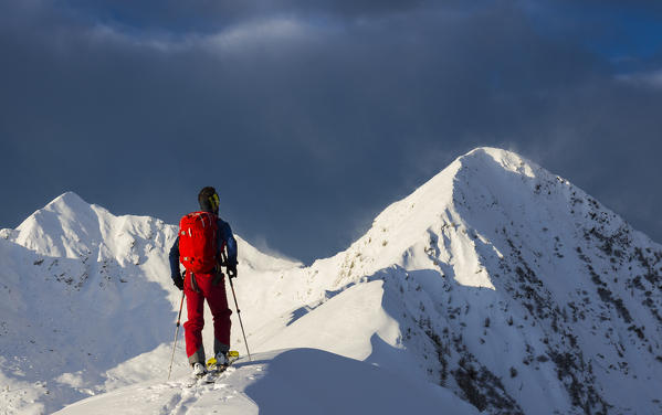 Skier facing Monte Colombana,, Valgerola, Valtellina, Lombardy, Italy, Alps