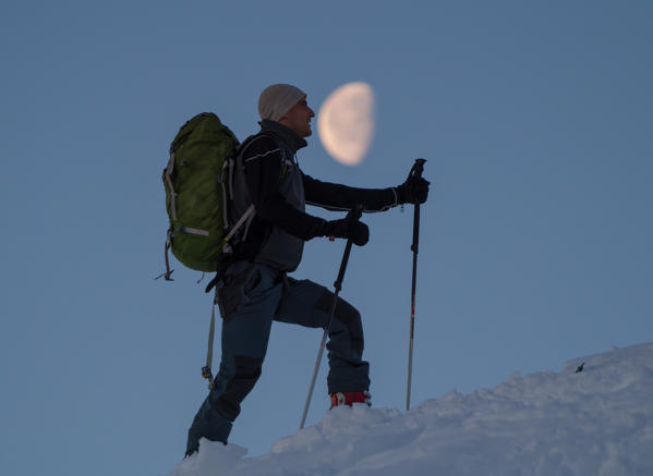 A skier with the moon, Valgerola, Valtellina, Lombardy, Italy