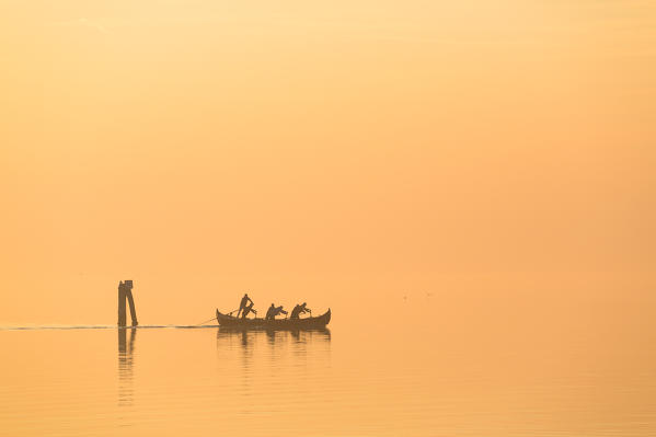 Boat in the misty lagoon at sunset, Venice, Veneto, Italy