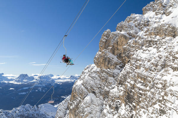 Blue sky on the skiers on Staunies chairlift surrounded by rocky peaks of the Dolomites Cortina D'Ampezzo Belluno Province Veneto Italy Europe