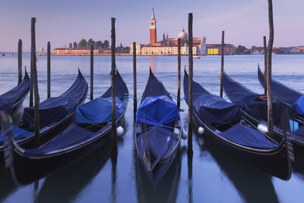 Europe, Italy, Veneto, Venice. The gondolas swaying rocked by the sea in the Grand Canal, in front of St. Giorgio Maggiore.