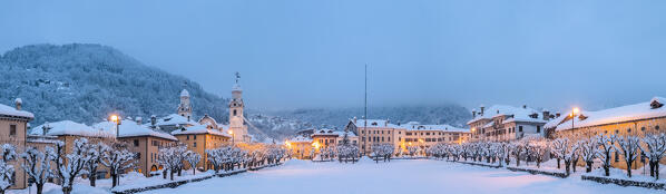 Europe, Italy, Veneto, Belluno province. The historic center of Agordo with the church and the snow-covered park of Broi