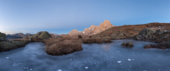 Europe, Italy, Trentino Alto Adige. Icy small pond on Cavallazza Piccola group of Lagorai. In the background the mountain Mulaz and Cimon della Pala, Pale di San Martino, Dolomites