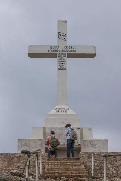 Europe, Balkans, Bosnia and Herzegovina, Medjugorje. Pilgrims praying near the big cross on the Hill Krizevac