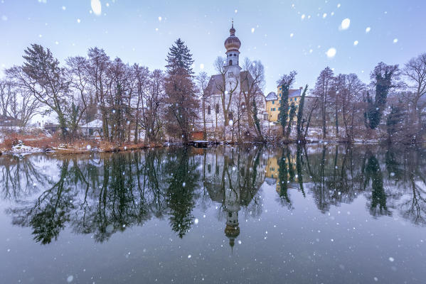 Hoeglwoerth abbey of St Peter and Paul and the lake under a snowfall, augustinian monastery near Anger, Rupertiwinkel, Upper Bavaria, Germany