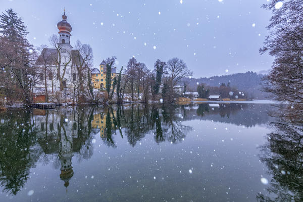 Hoeglwoerth abbey of St Peter and Paul and the lake under a snowfall, augustinian monastery near Anger, Rupertiwinkel, Upper Bavaria, Germany