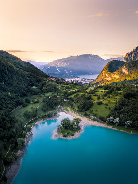 Sunrise in Tenno Lake with Riva del Garda and Baldo mountain on the background. Tenno, Trentino Alto Adige, Italy