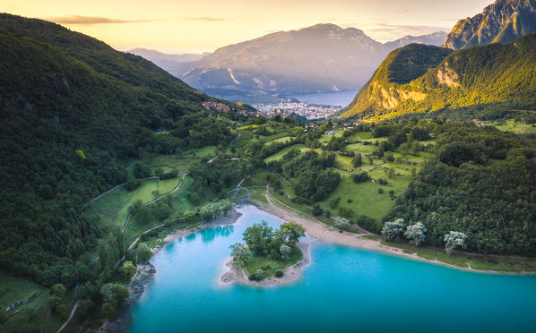 Sunrise in Tenno Lake with Riva del Garda and Baldo mountain on the background. Tenno, Trentino Alto Adige, Italy