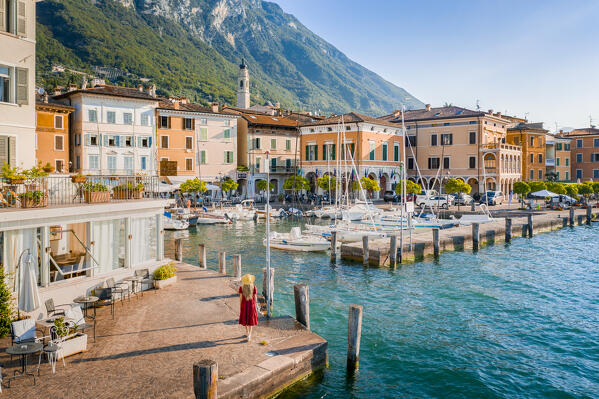 Blonde girl with red dress walking in Gargnano, a small village on Garda Lake, Brescia province, Lombardy, Italy