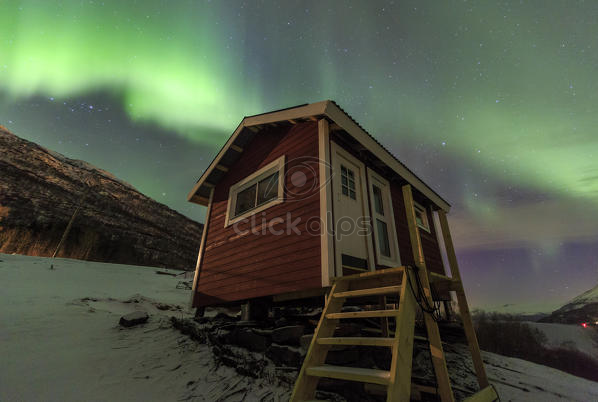 The Northern Lights Illuminates The Wooden Cabin Oteren