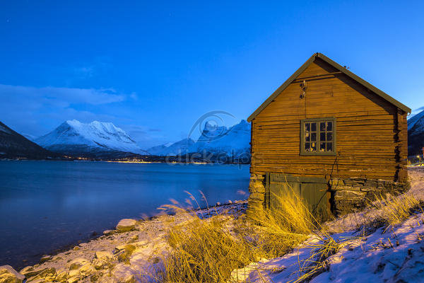 Wooden Cabin Of Fisherman Illuminated Surrounded By The Frozen Sea