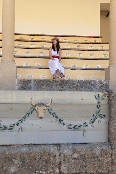 A tourist sitting in the stands on the Ronda bullring, Plaza de Toros, Ronda, province of Málaga, Andalusia, Spain