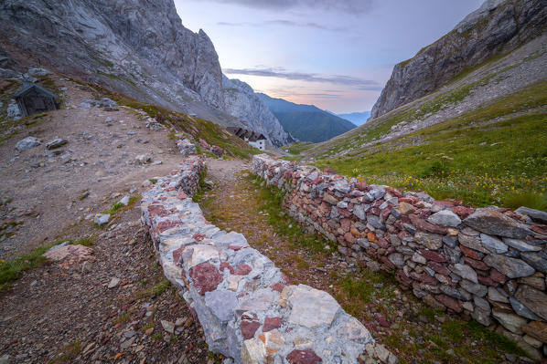 A trench of WWI at Volaia Pass, with Lambertenghi-Romanin refuge on the background, Carnic Alps, Forni Avoltri, Udine province, Friuli Venezia Giulia, Italy.