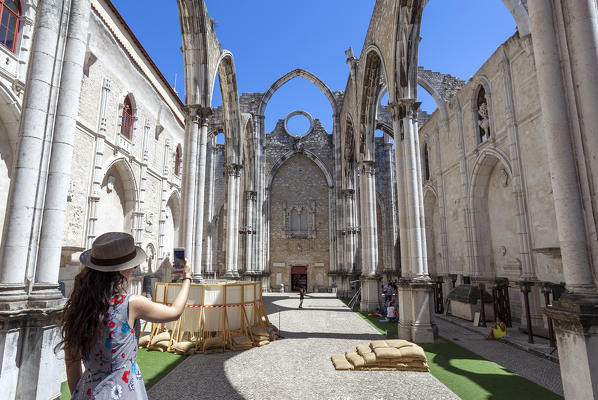 A tourist takes a shot of interior of Igreja do Carmo (Carmo Convent), Chiado Neighborhood, Lisbon, Lisbon Metropolitan Area, Portugal. The roof of the curch collapsed after 1755 heartquake.