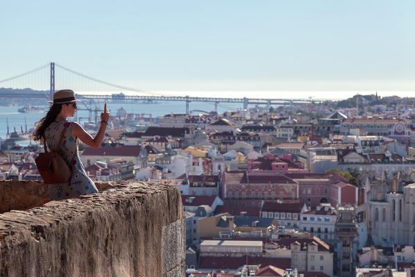 A woman while photographing Lisbon from the panoramic terrace of Castelo de São Jorge (St George's Castle), Alfama Neighborhood, Lisbon, Lisbon Metropolitan Area, Portugal