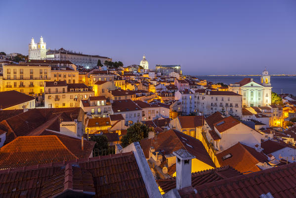 Overview at dusk of the roofs of Alfama Neighborhood with Igreja de São Vicente de Fora, Igreja de Santa Engràcia and Igreja de São Estevão on the background from Miraduro de Santa Luzia (St Lucy viewpoint), Alfama Neighborhood, Lisbon, Lisbon Metropolitan Area, Portugal