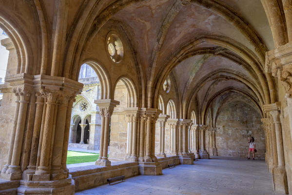 A tourist photograps the arches of the cloister of the Old Cathedral (Sé Velha), Coimbra, Coimbra district, Centro Region, Portugal.