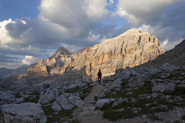 A hiker observes the sunset on Tofane from Forcella Travenanzes, Dolomites, Cortina d'Ampezzo, Belluno province, Veneto, Italy.