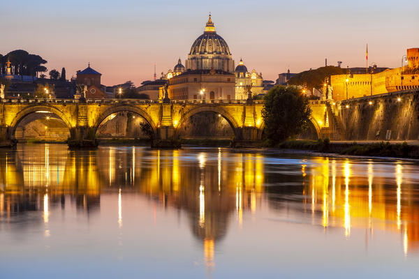 Ponte Sant'Angelo with St. Peter's Basilica on the background at dusk reflected on Tiber river, Rome, Lazio, Italy.