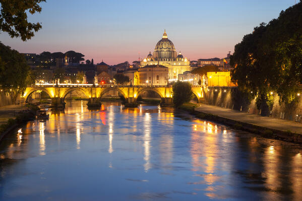 Ponte Sant'Angelo with St. Peter's Basilica on the background at dusk reflected on Tiber river, Rome, Lazio, Italy.