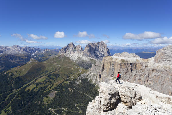 A hiker admires Fassa Valley and Sassolungo Group from Sass Pordoi, Sella Group, Dolomites, Canazei, Trento province, Trentino - Alto Adige, Italy. (MR)