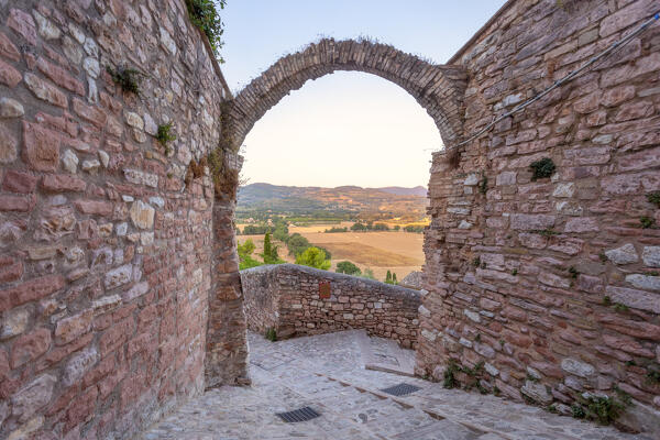 A characteristic corner in Spello with hills and valley below, Perugia province, Umbria region, Italy.