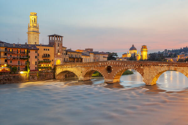 Ponte Pietra at dusk, with the bell tower of Verona Cathedral on the left and San Giorgio in Braida on the right. Verona, Veneto, Italy.