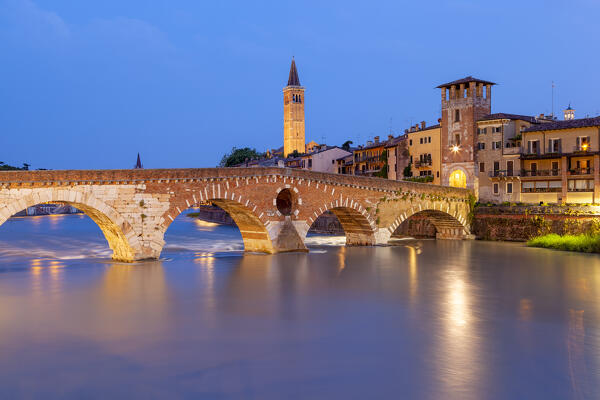 Ponte Pietra and Basilica of Saint Anastasia bell tower at dusk from from Ponte Pietra. Verona, Veneto, Italy.