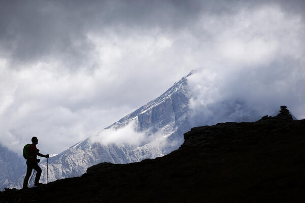 A hiker on the ridge of Penna Mount, with Antelao on the background, Dolomites, Zoppè di Cadore,  Belluno province, Veneto, Italy.