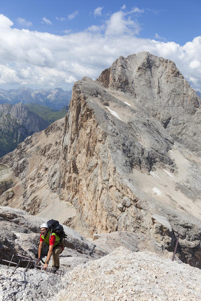 A mountaineer climbs the Via Ferrata of West Ridge, Marmolada group, Dolomites, Canazei, Trento province, Trentino-Alto Adige, Italy