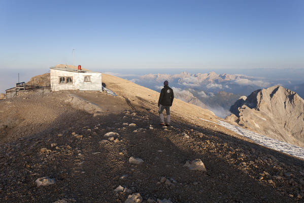 Hiker at Punta Penia hut, Marmolada group, Dolomites, Canazei, Trento province, Trentino-Alto Adige, Italy
