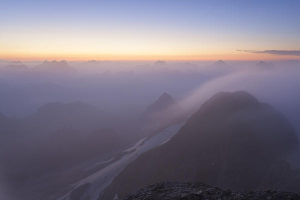 A foggy dawn from Punta Penia, Marmolada group, Dolomites, Canazei, Trento province, Trentino-Alto Adige, Italy