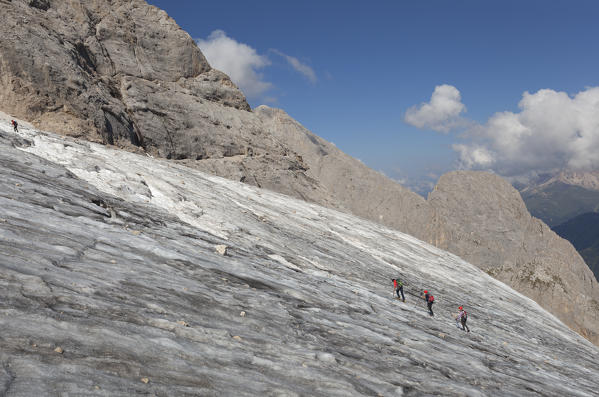 Three mountianeers climb the Marmolada glacier, Marmolada group, Dolomites, Canazei, Trento province, Trentino-Alto Adige, Italy