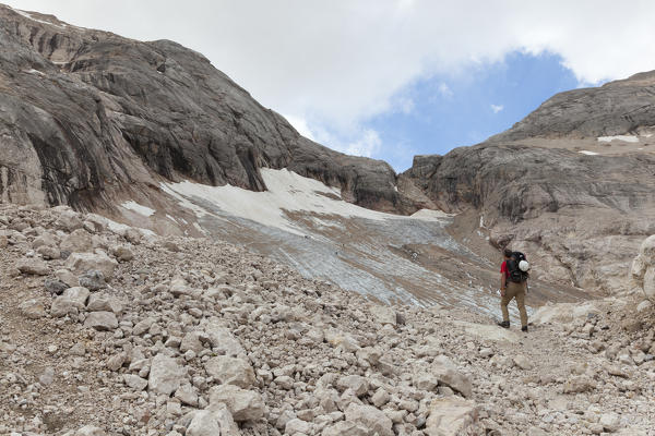 A hiker looks the Vernel Glacier, Marmolada group, Dolomites, Canazei, Trento province, Trentino-Alto Adige, Italy
