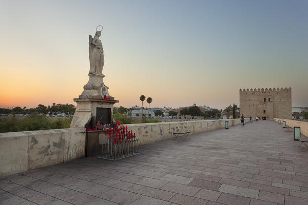 An angel statue on Roman Bridge, with Calahorra Toweron background, Córdoba municipality, province of Córdoba, Andalusia, Spain