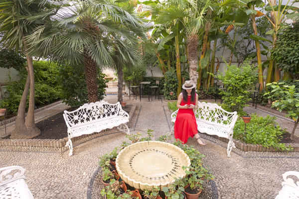 A woman in a traditional andalusian courtyard (patio), Córdoba municipality, province of Córdoba, Andalusia, Spain (MR)