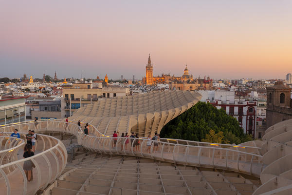 Tourists on the curved footbridge of Metropol Parasol at sunset, Seville, province of Seville, Andalusia, Spain