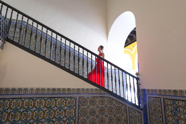 A woman on the staircase of Palacio de Pedro I (Palace of Peter I), Royal Alcazars of Seville, Seville, province of Seville, Andalusia, Spain